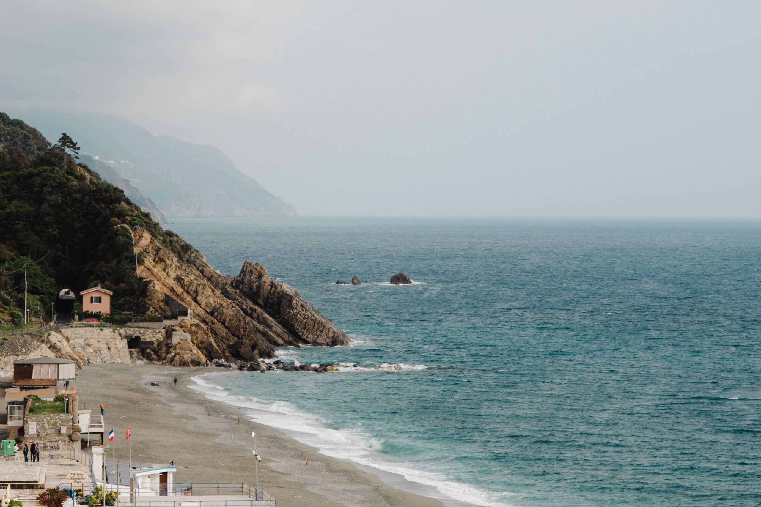 A calm coastline where cliffs meet the sea under a soft, overcast sky