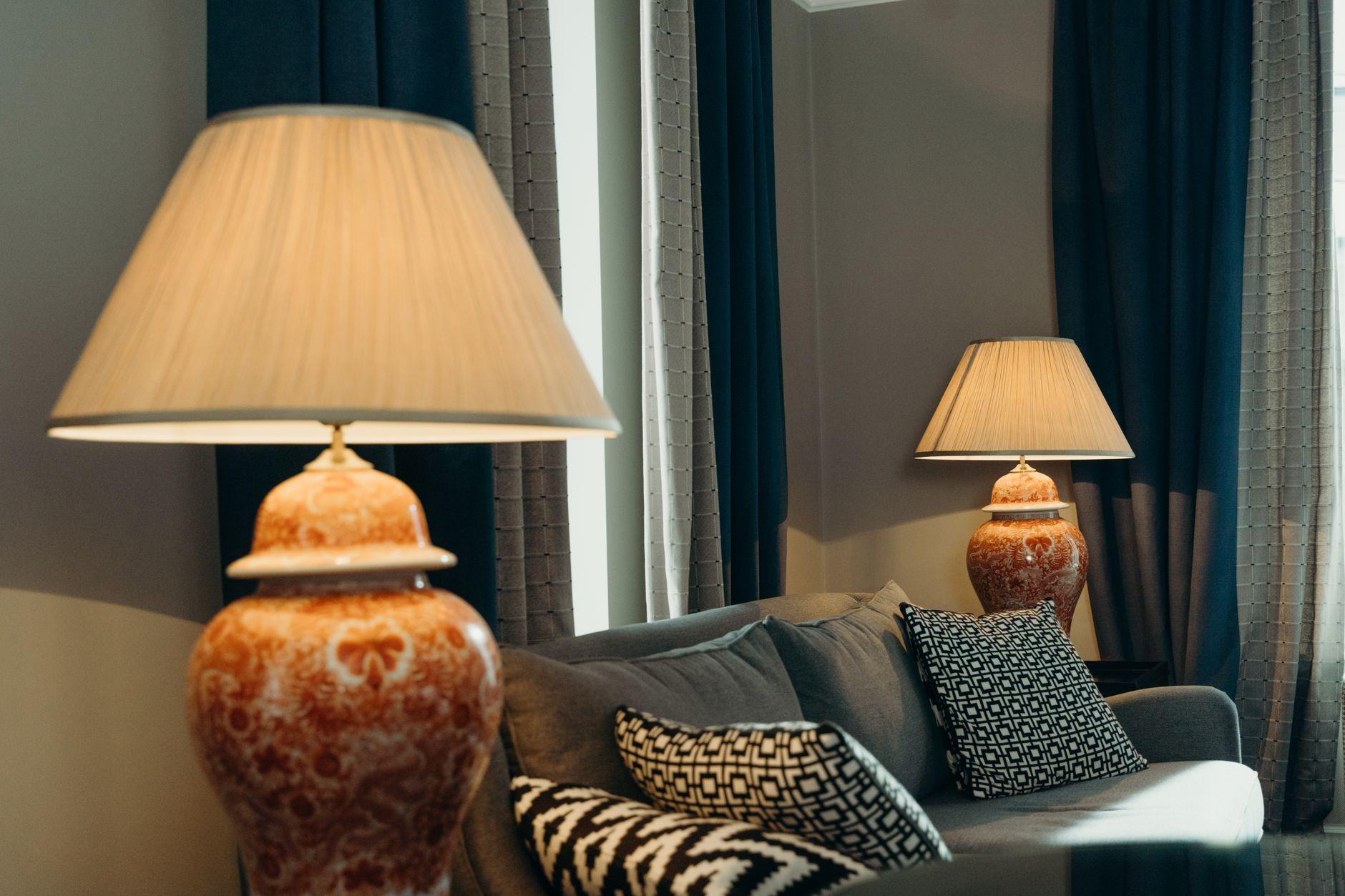 A sunlit high-floor lounge with soft neutral seating and a panoramic city view