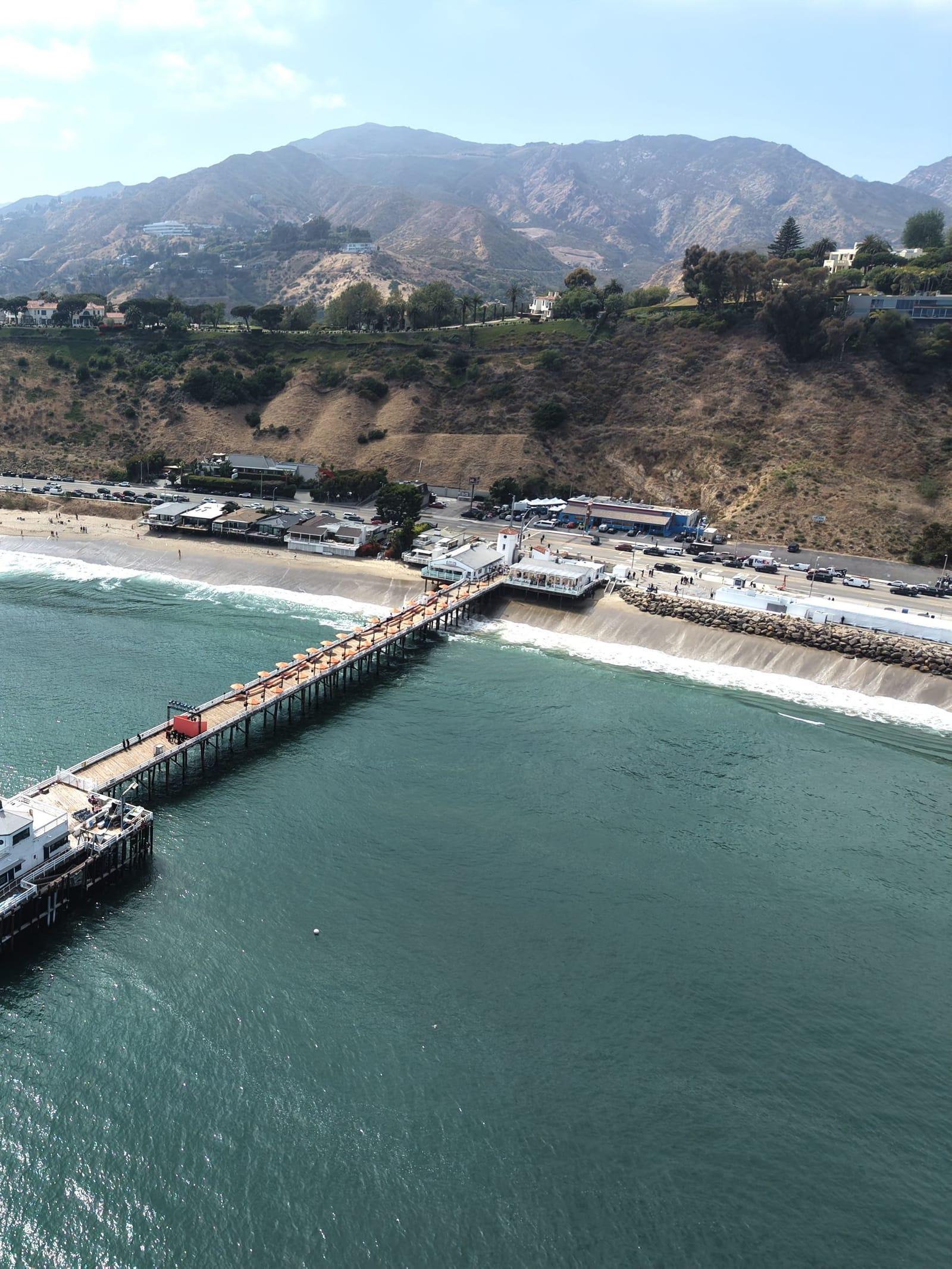 Malibu Pier and the coastline from above, with the mountains behind