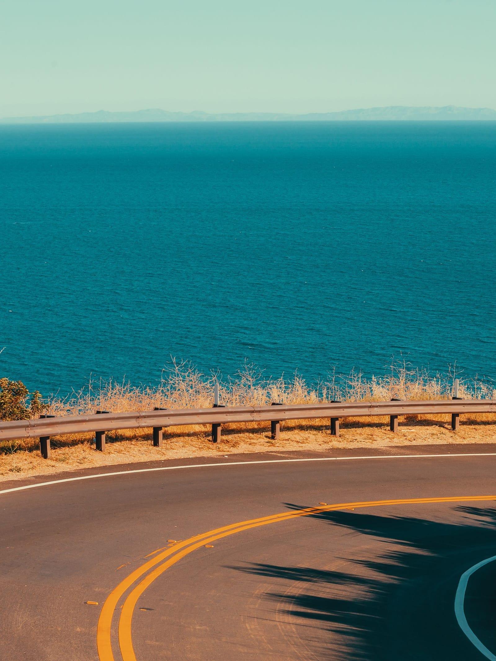 The coast highway curving above a blue Malibu sea