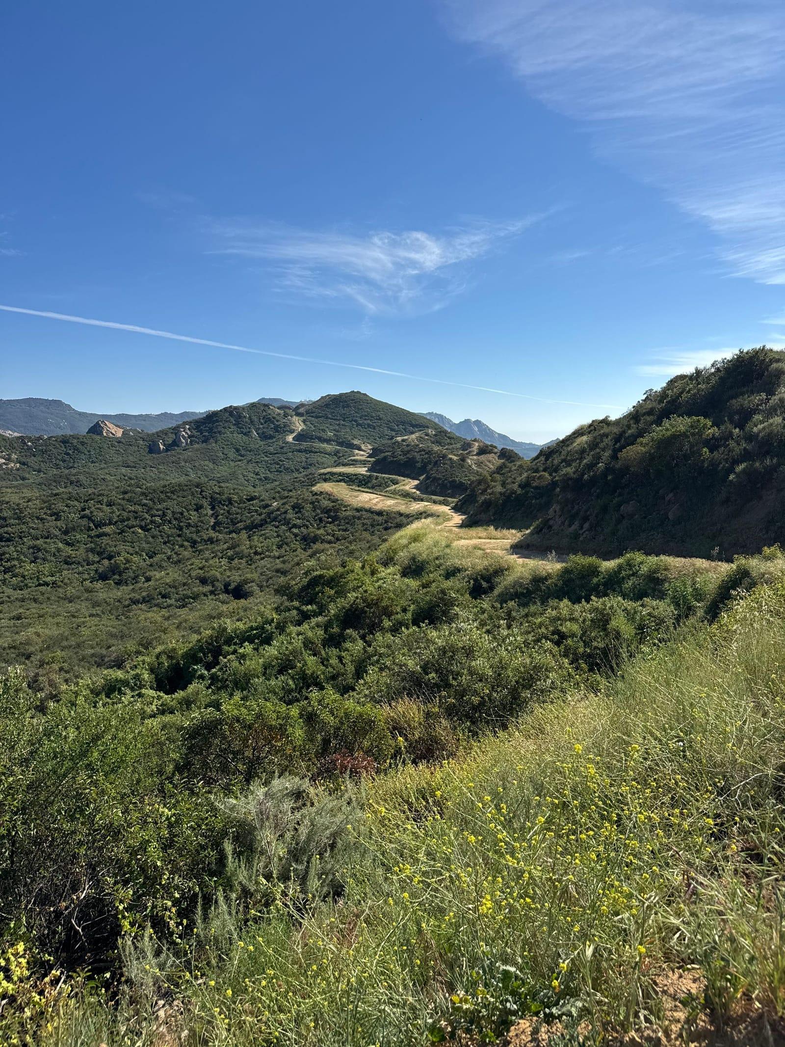 Green hills and a winding trail in the mountains above Malibu on a clear day