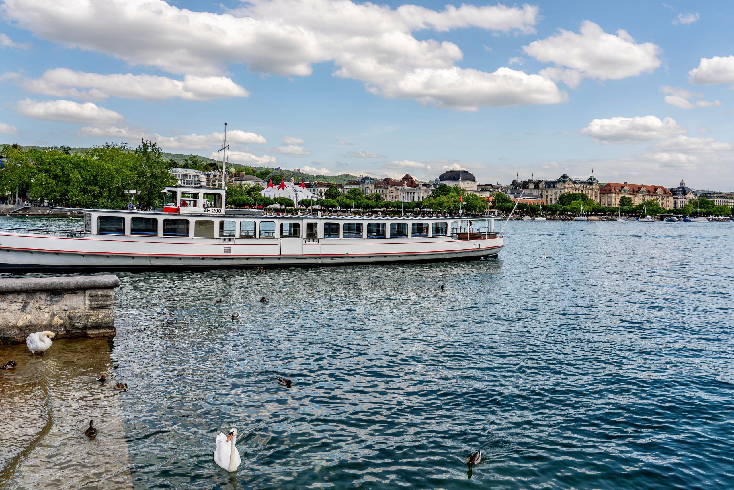 A Zurich lake steamer alongside the city shore of Lake Zurich on a clear summer day