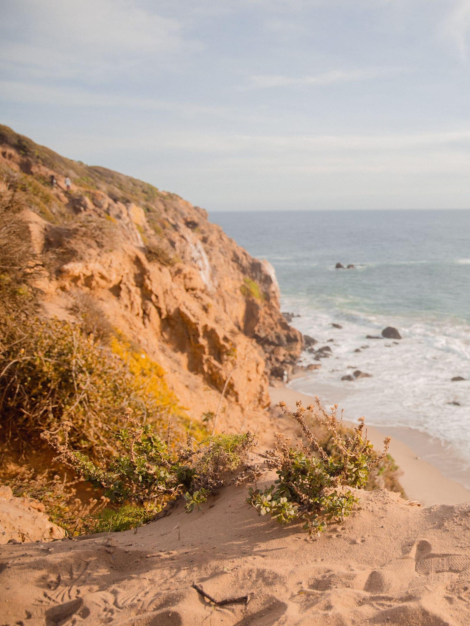 A sandy bluff above a Malibu beach and calm blue ocean