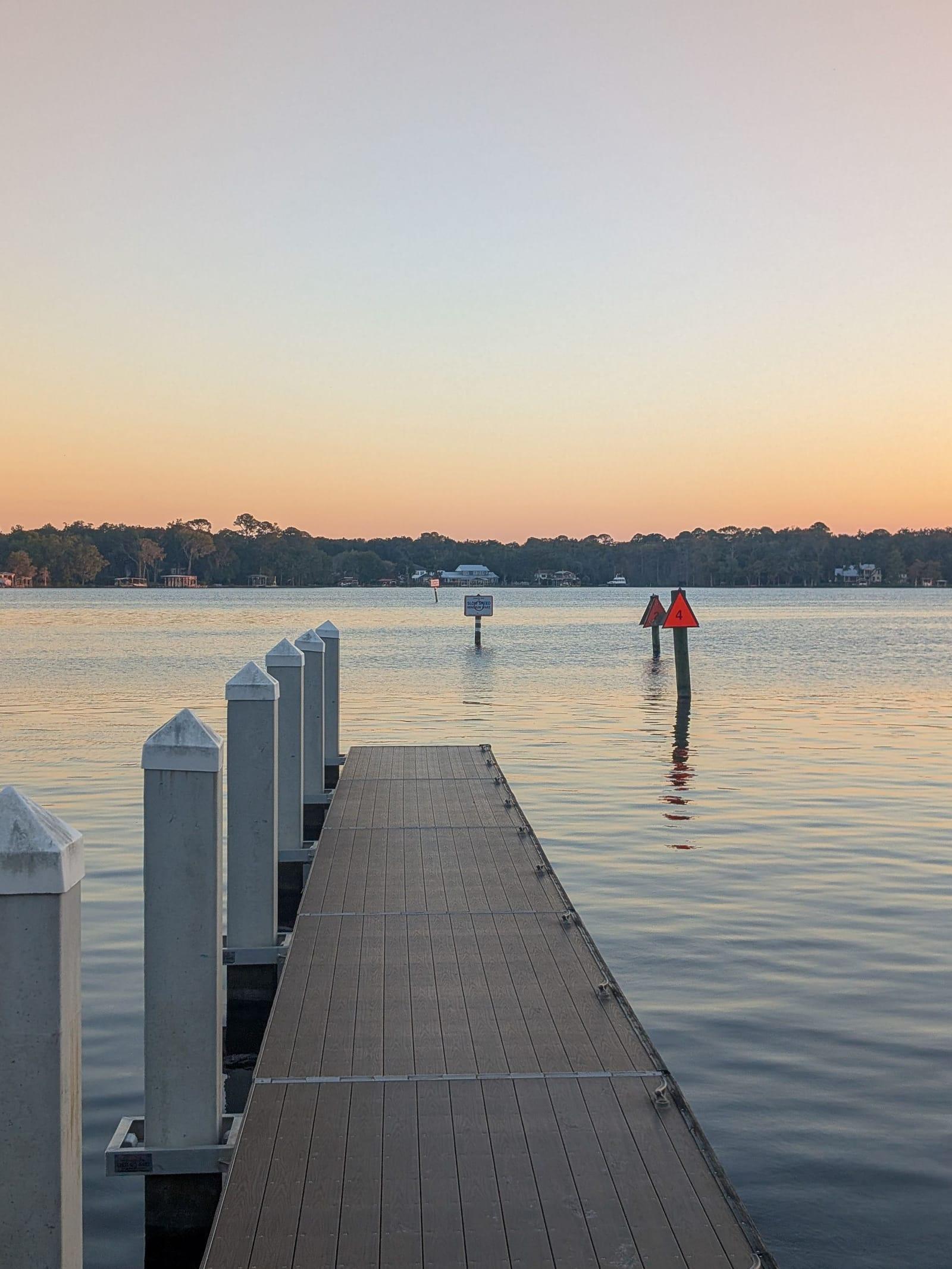A dock running out over calm water at dusk