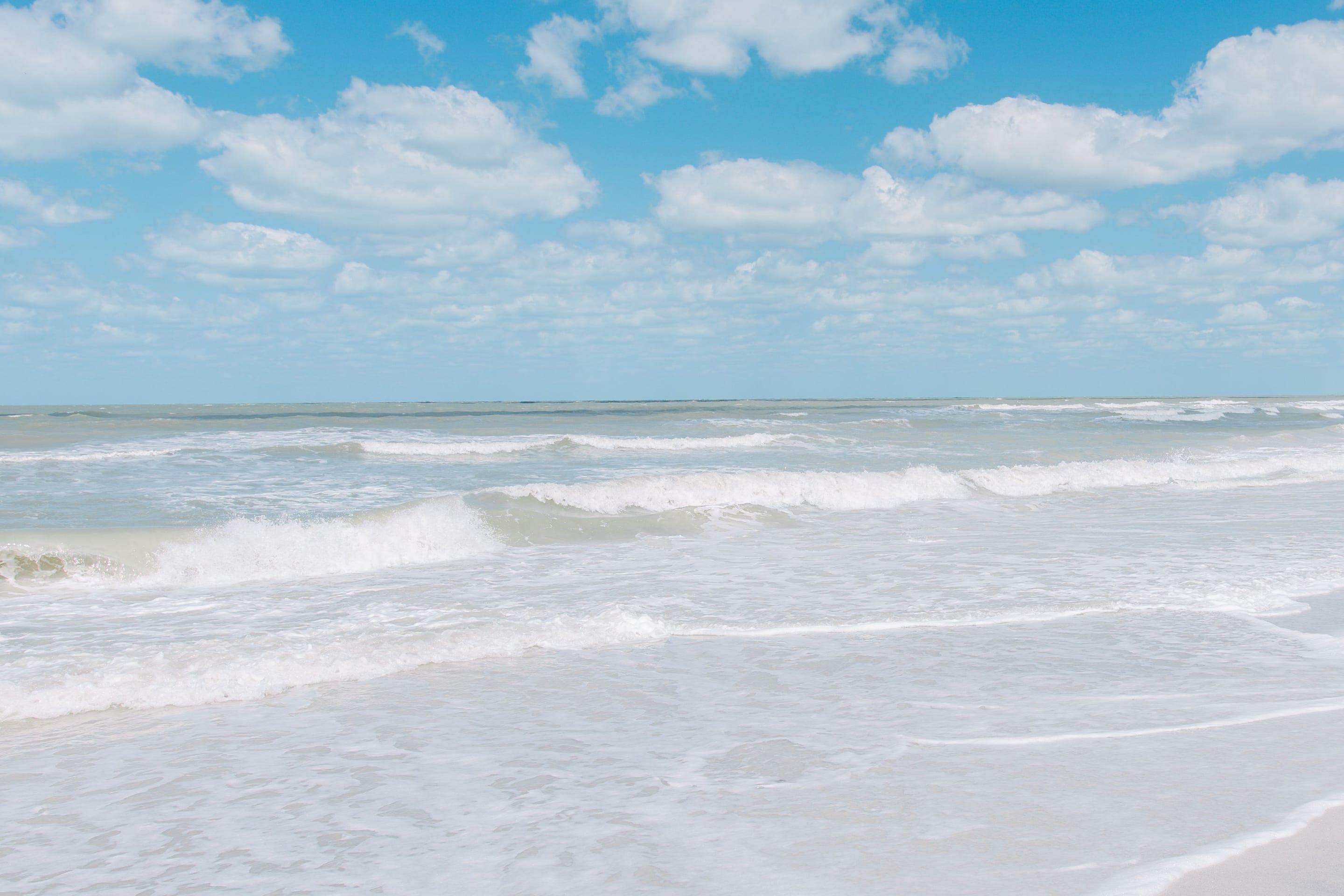 Small waves rolling onto St. Pete Beach, Florida, under a bright blue sky