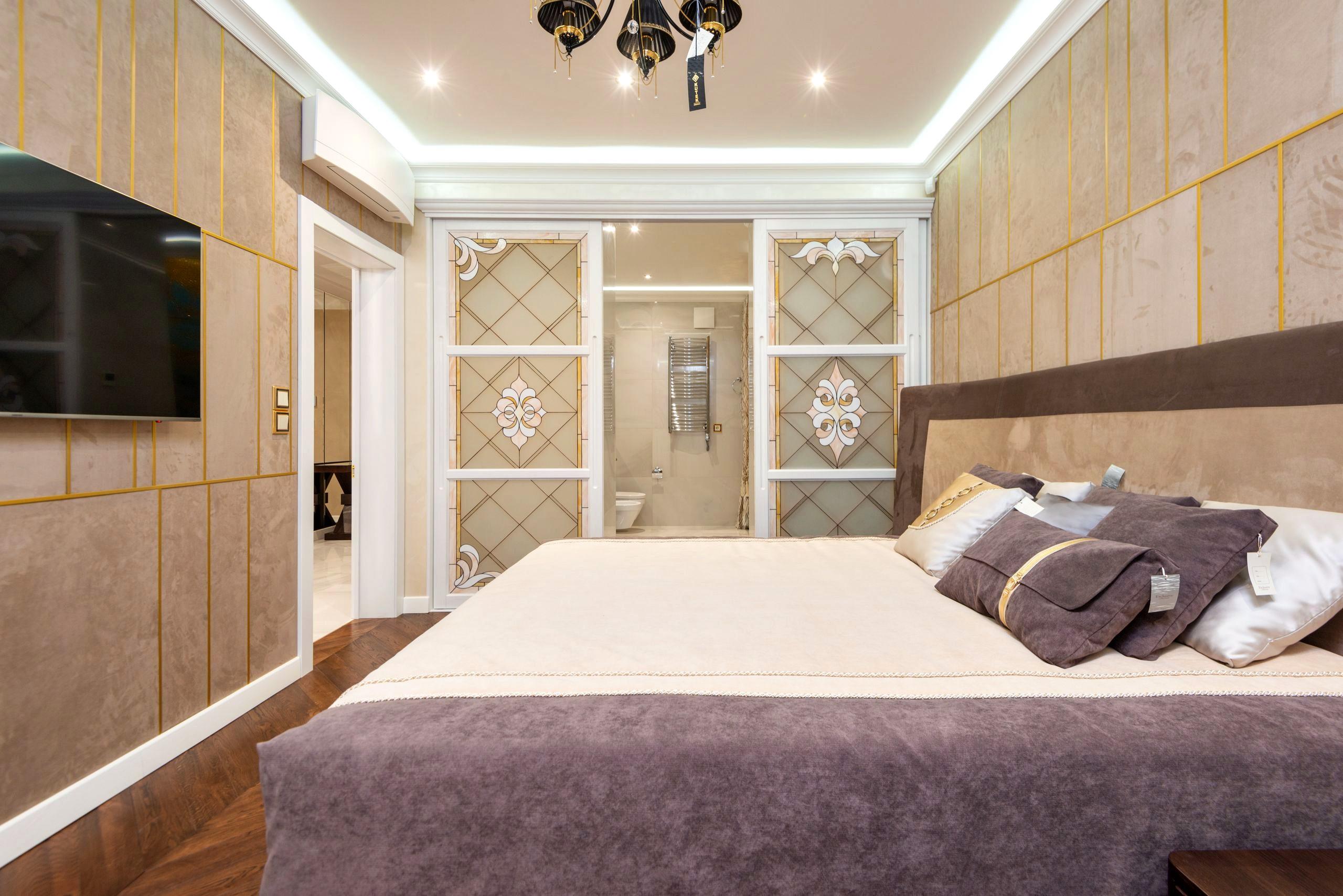 A bright, upscale bedroom suite with soft natural light, neutral tones, and elegant detailing