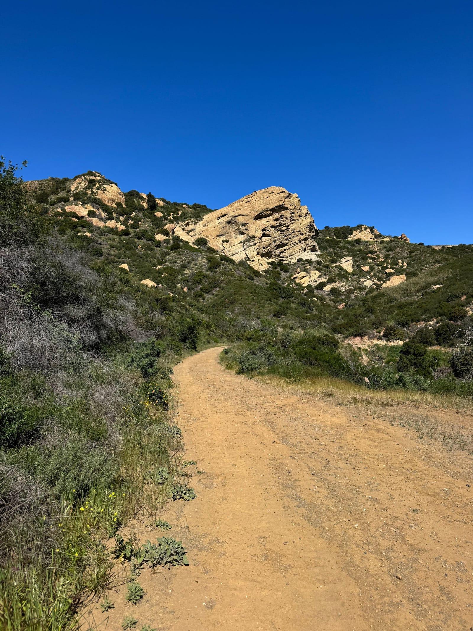 A sunny trail past sandstone outcrops in the Santa Monica Mountains