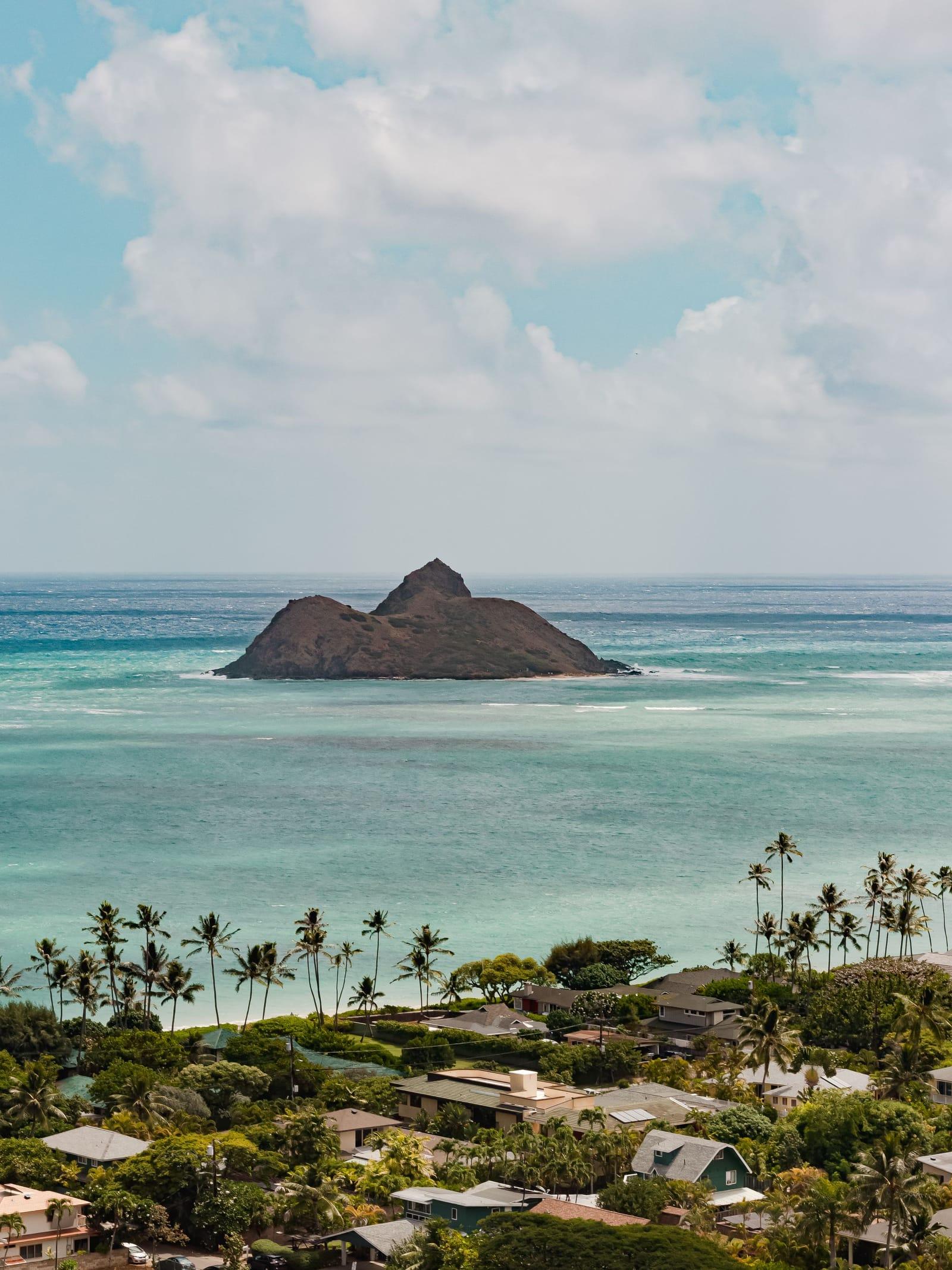 A small islet off Oahu's palm-lined windward coast, turquoise water between