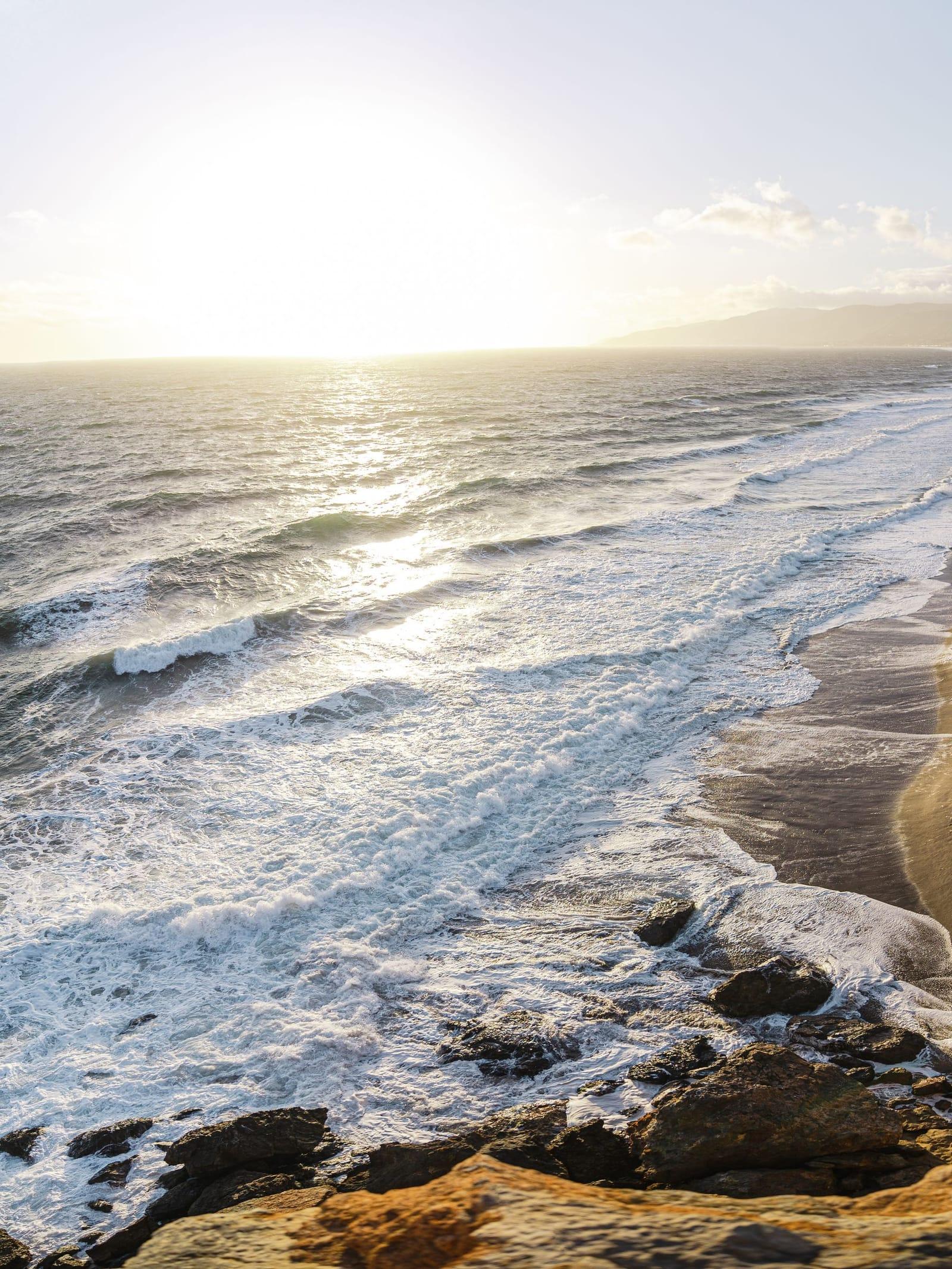 Sunlit waves washing over the Malibu shoreline